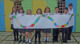 Children holding up scarf artwork.