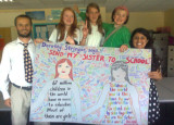 Teachers and pupils hold up large 'Send My Sister' banner, with signatures